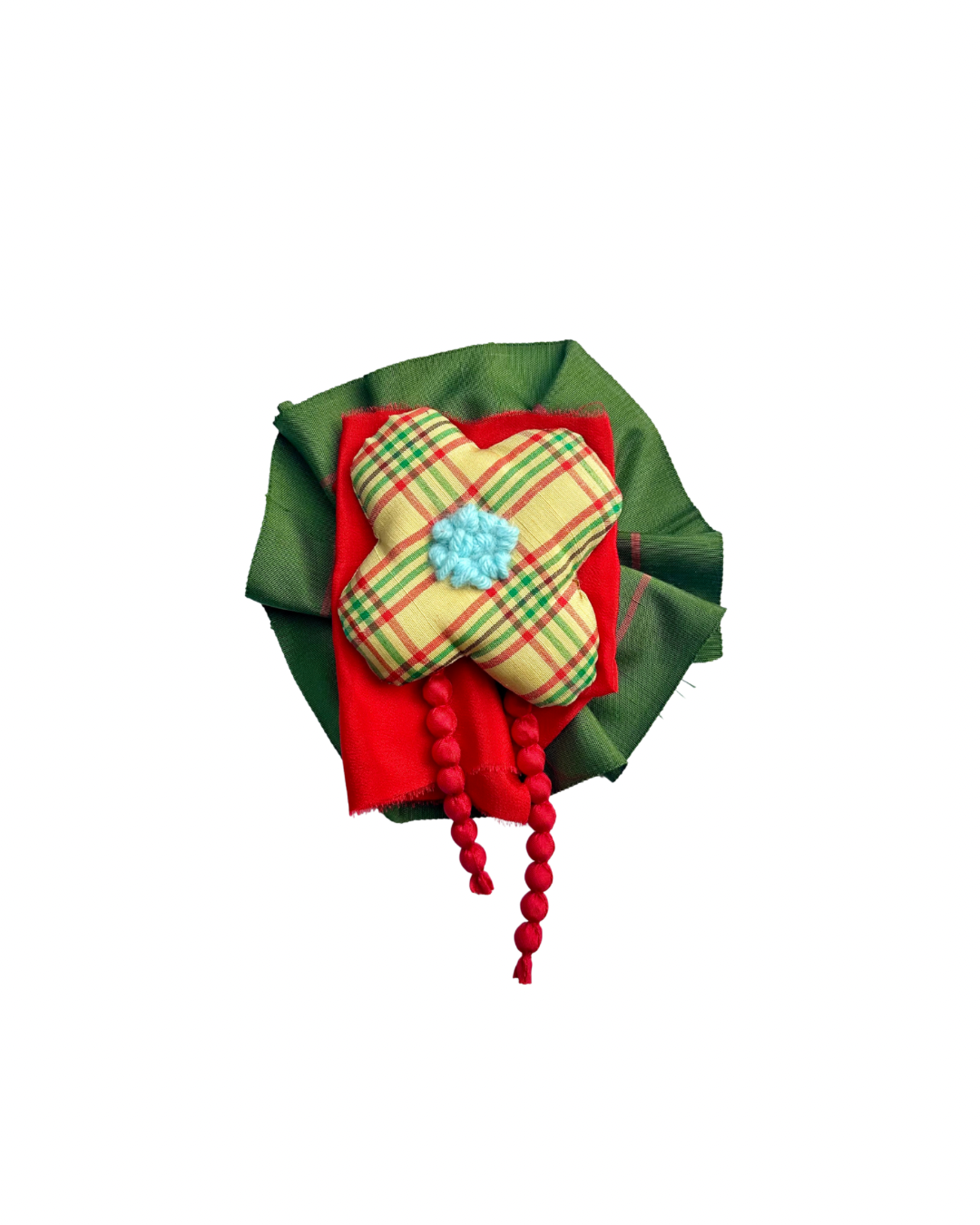 A decorative rosette brooch featuring a green fabric wreath with a red fabric base, a yellow plaid flower-shaped ornament, and a small mint green flower center, with red bead strands hanging down, isolated on a white background.