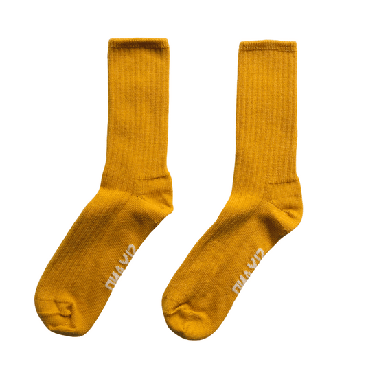 Pair of mustard yellow socks with brand logo on a white background