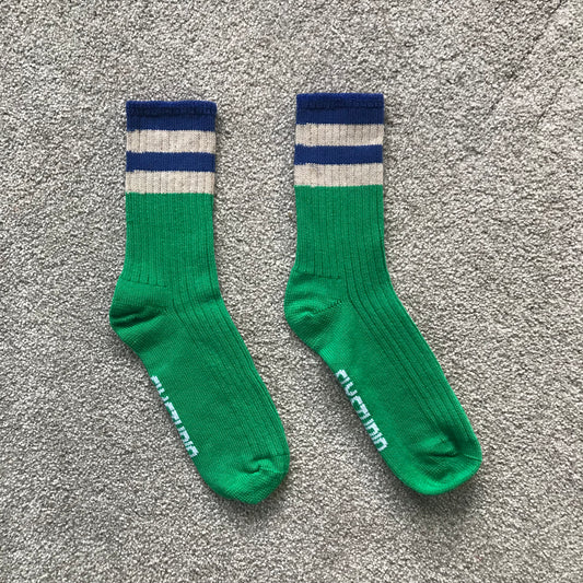 Pair of green socks with blue and gray stripes on a white background