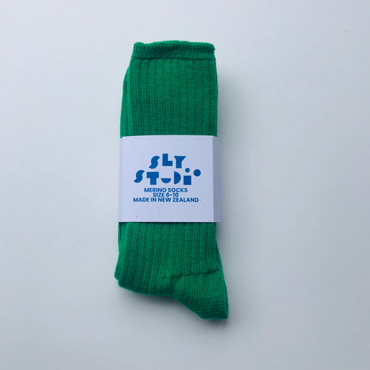 Green sock with a white label on a light gray background